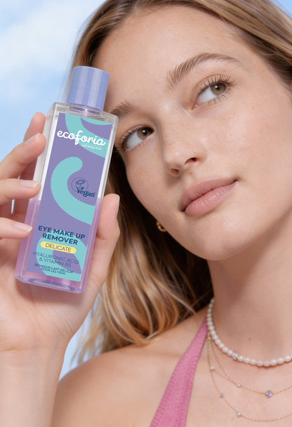 Woman holding ecoforia eye makeup remover bottle with a close-up of her face.